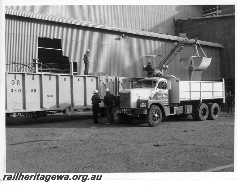 P10734
A grab bucket loading a Bell Bros tipper with a commodity from a WG glass 33088 standard gauge open wagon.
