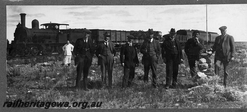 P16827
Commonwealth Railways (CR) - TAR line inspection train hauled by a D class steam locomotive at the WA/SA boarder. The D class steam locomotives were the original locomotives used on the construction trains. These locomotives were purchased second hand from the NSWGR. The original stone cairn is depicted in the photo. 
