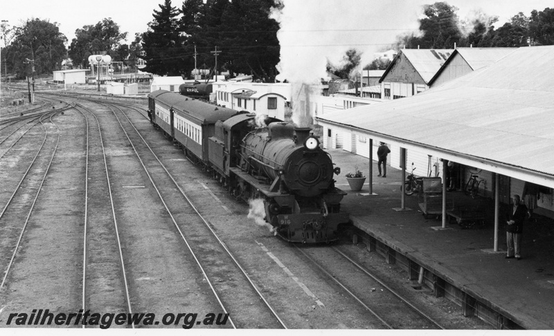 P17562
5 of 6 W class 916 steam locomotive heads Holiday weekender, two AQZ class carriages and MRWA brakevan, side and front view, station building, passenger platform, Collie, BN line..
