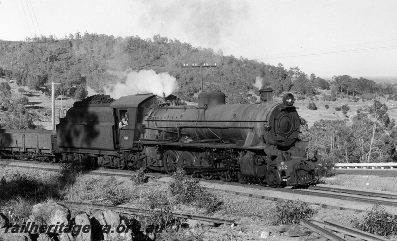 P17629
W class 942 steam locomotive working a Pinjarra to Dwellingup goods approaching a level crossing. Note the removed rails in the foreground. PN line. See P17627 and P17628.
