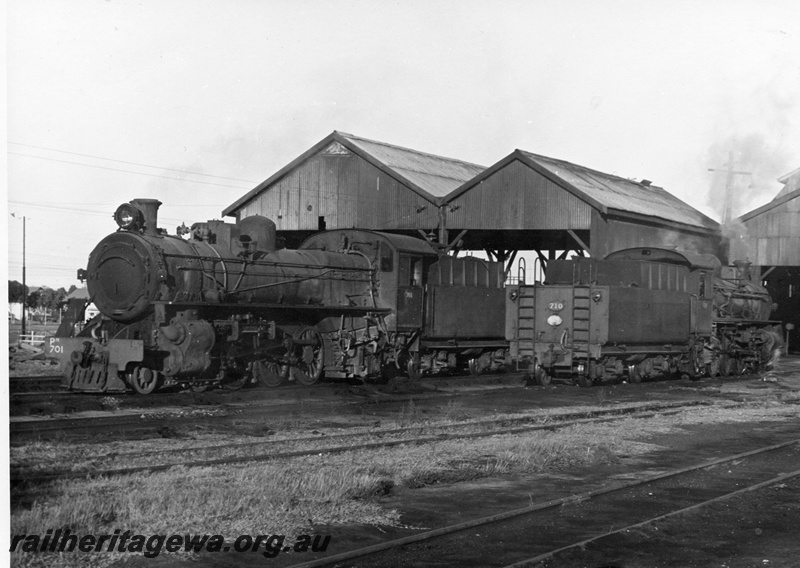 P17744
PM class 701 & PM class 710 steam locomotives standing outside the former Northam Steam Loco Depot. ER line. Both locos are still operational and show views of front and rear.
