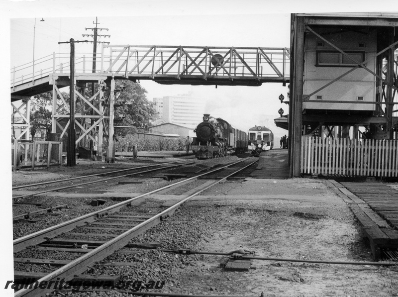 P17765
PMR class 730 steam locomotive on 37 Goods and unidentified ADG suburban railcar at East Perth. SWR line. Note overhead footbridge and portion of signal box. Points rodding in foreground.
