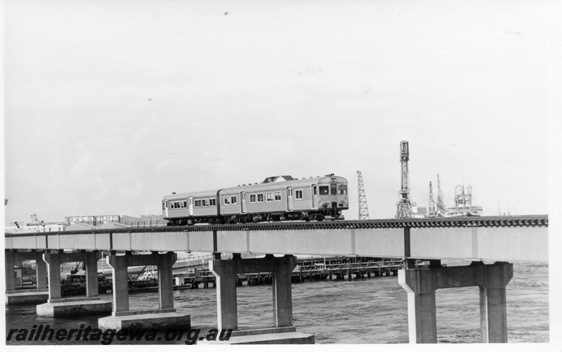 P17813
An unidentified ADK/ADB railcar set crossing the railway bridge over the Swan River at Fremantle. ER line. The train is travelling to Perth.
