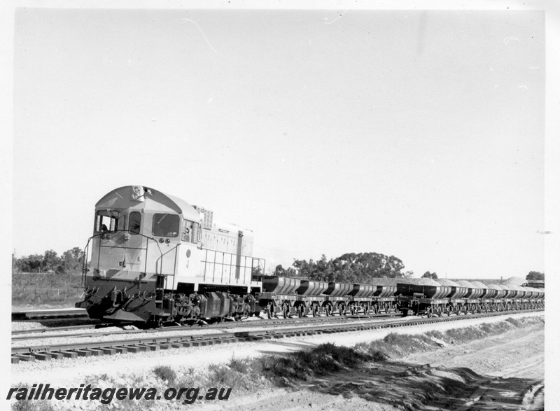 P17865
J class 101 standard gauge diesel locomotive with an empty rake of WSJ class 4 wheeled ballast hoppers in the vicinity of the Kenwick Flyover. Note the loaded ballast hoppers to the right.
