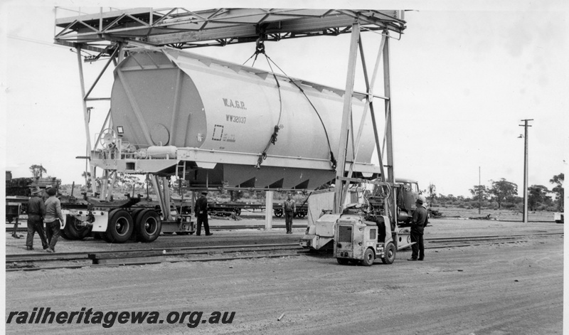 P17876
WW class 32037 standard gauge wheat hopper being loaded onto prime mover and jinker at Parkeston for transport to West Merredin.

