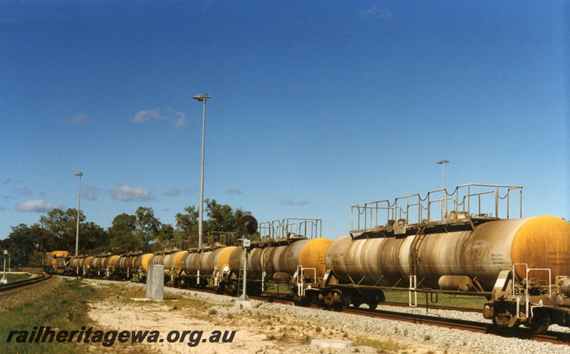 P18032
Diesel hauled caustic soda train bound for Pinjarra, departing Kwinana, light signal, track level view from rear of train
