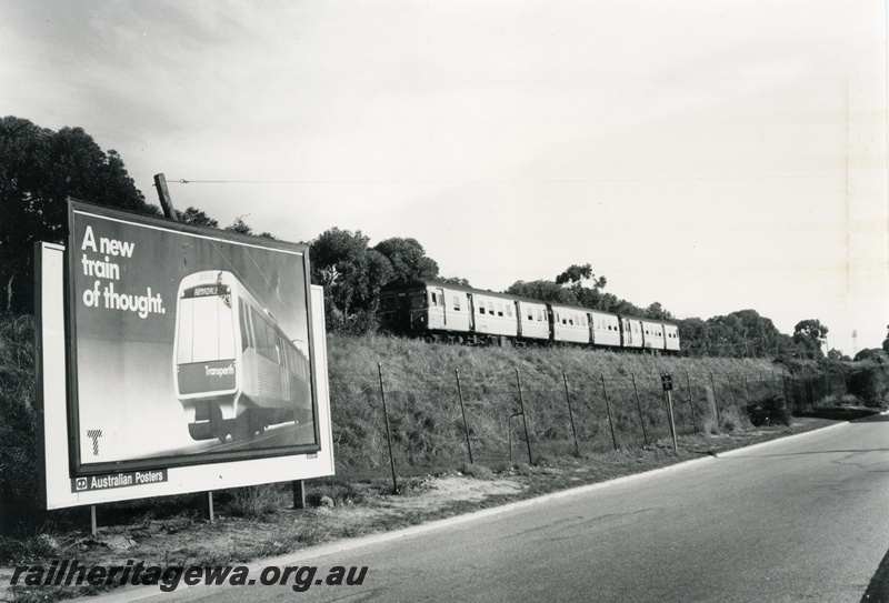 P18052
DMU three car set, on Fremantle to Perth passenger service, bill board beside track advertising the soon to arrive electric service with picture and the slogan 