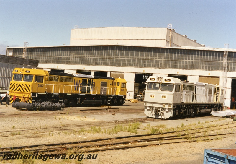 P18055
S class 2102, painted yellow, and S class 2104, painted white, under construction at Clyde Engineering, industrial buildings, Forrestfield, end and side views
