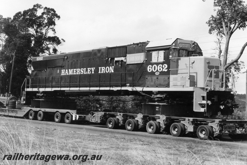 P18116
1 of 4 Hamersley Iron 6062 class diesel locomotive being road hauled from Kewdale to Dampier. Loco is spread across 2 trailers.
