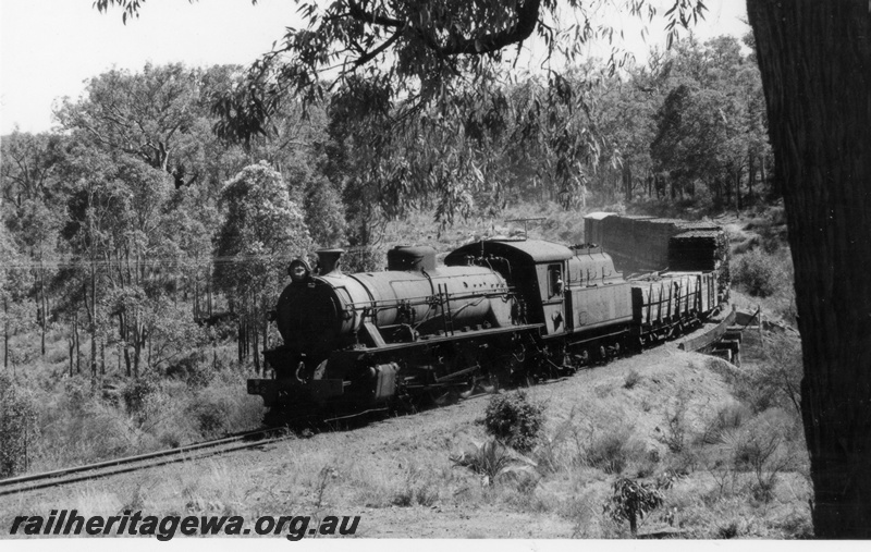 P18232
W class 942 steam locomotive on goods train, front and side view, crossing bridge between Dwellingup and Pinjarra, PN line.
