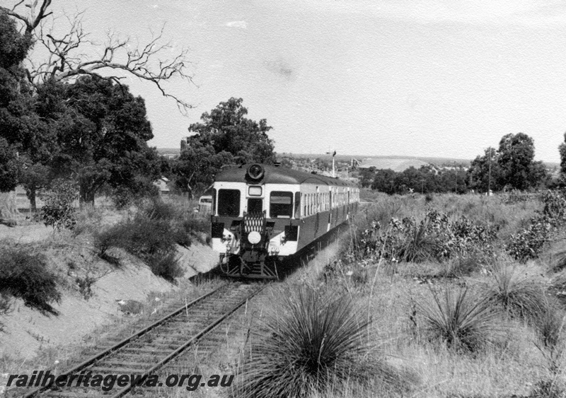 P18338
ADA class railcar trailer on a railcar set heading towards Midland from Koongamia, M line, the now demolished wheat silo at Bellevue in the background
