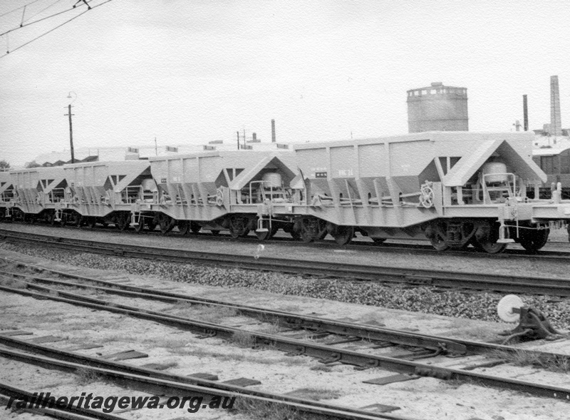 P18344
3 of 4, Rake of WMC class hoppers, points in foreground with cheese knob, side and end view, East Perth gasometer in the background.
