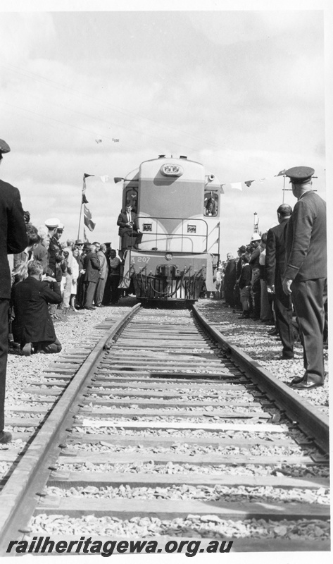 P18471
2 of 12 images relating to the ceremony for the linking of the standard gauge railways at Kalgoorlie, K class 207, driven by WA Premier Brand over the recently completed section of standard gauge track, spectators, Kalgoorlie, front on view
