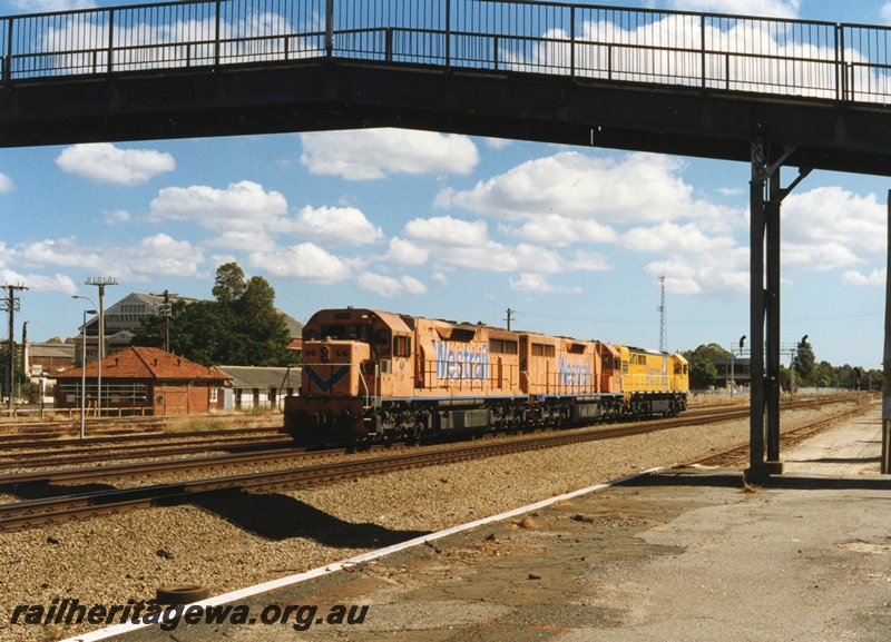 P18655
Q class 316 standard gauge diesel locomotive on trail with L class 260 and 268 at Midland. First 2 locomotives in Westrail Orange paint scheme and Q class in yellow. Position of overhead footbridge from old Midland station to Workshops is visible. 
