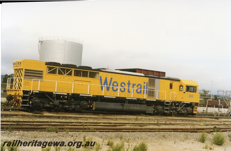 P18666
Q class 303 standard gauge diesel locomotive pictured at Forrestfield adjacent to portion of the carriage washing plant. Similar to P18665.
