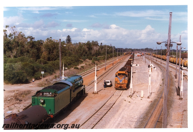P18724
New South Wales C Class Steam Locomotive 3801 entering Kwinana Yard as an unidentified L class diesel locomotive awaiting departure with an empty freight train. Elevated view along the yard
