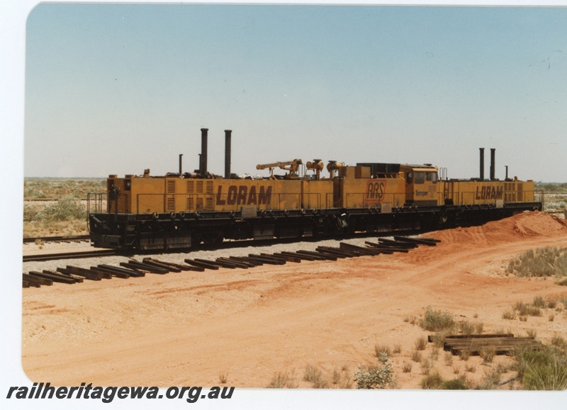 P18727
Loram rail grinder, used by BHP, sleepers beside track, Port Hedland, end and side view
