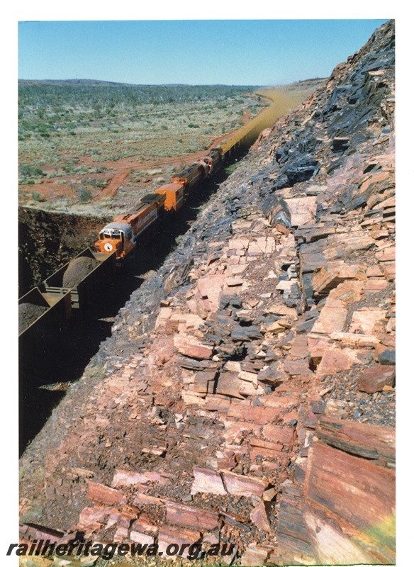 P18781
Mount Newman (MNM) M636 class 5481, Locotrol unit, M636 class 5474, 5479 rear half of loaded Locotrol train of Ore Body 29 iron ore. Photo taken from cutting. 
