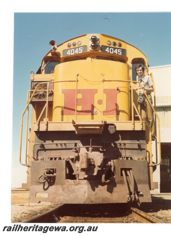 P18790
Hamersley Iron (HI) M 636 class 4045 - front view at 7 Mile Dampier. Allan Tilley standing on front of locomotive.
