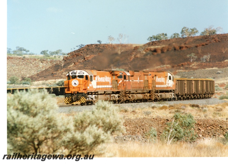 P18791
Mount Newman (MNM) M 636 class 5495, 5467, 5477 haul loaded ore train near Garden. 
