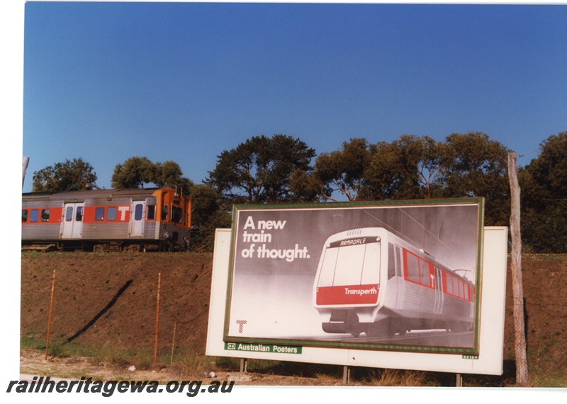 P18796
Transperth ADL class railcar passing new sign advertising the introduction of electric trains for Perth at Karrakatta.

