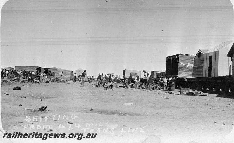 P19169
Commonwealth Railways (CR) construction camp being shifted, workers, buildings being loaded onto flat wagons, 474 mile, TAR line
