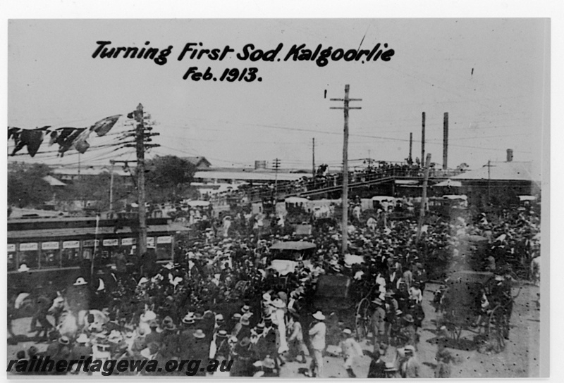P19178
Turning the first sod for the Commonwealth Railways (CR) Trans-Australian Railway, station building, overhead footbridge, horse drawn carriages, crowds, Kalgoorlie, TAR line, elevated view
