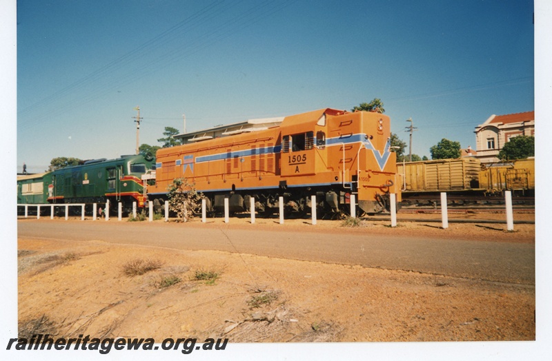 P19253
A class 1505, in orange livery with blue and white stripe, XA class in green livery with red and yellow stripe, on passenger train, wagons, Narrogin, GSR line, side and front view
