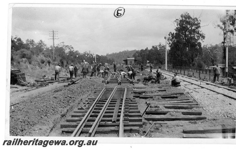 P19656
4 of 5 images of the installation of a double compound (double slip) at Parkerville, ER line. Images 1 & 2 in the sequence are numbered P01052 & P01053. This image, taken at 11.30 am shows the pointwork in position on the mainline and lowered from skids to the formation. 
