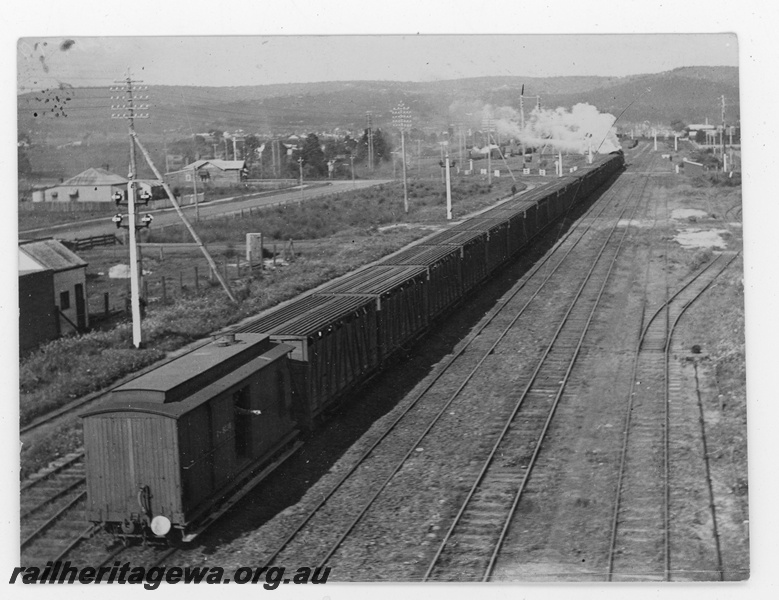 P19658
A stock train being hauled by a steam loco heading east between Midland Junction and Bellevue, ER line, a clerestory roofed brakevan . Elevated view from the rear of the train looking eastwards.
