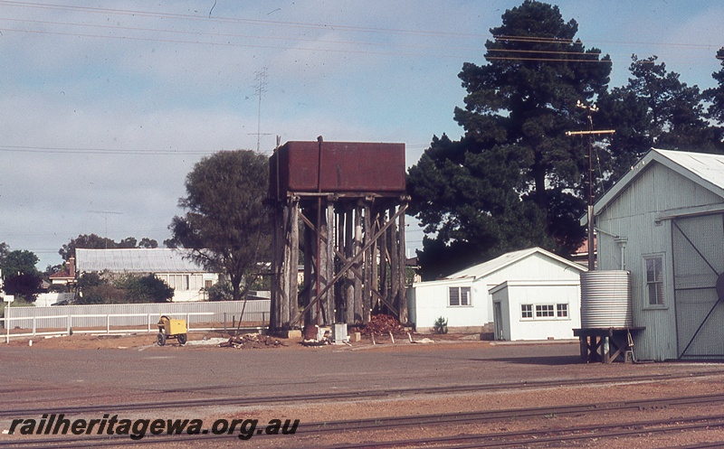 P19747
Water tower with a 25,000 cast iron tank,  trackside buildings, part view of the end of the goods shed with a rain water tank, track, Narrogin, GSR line
