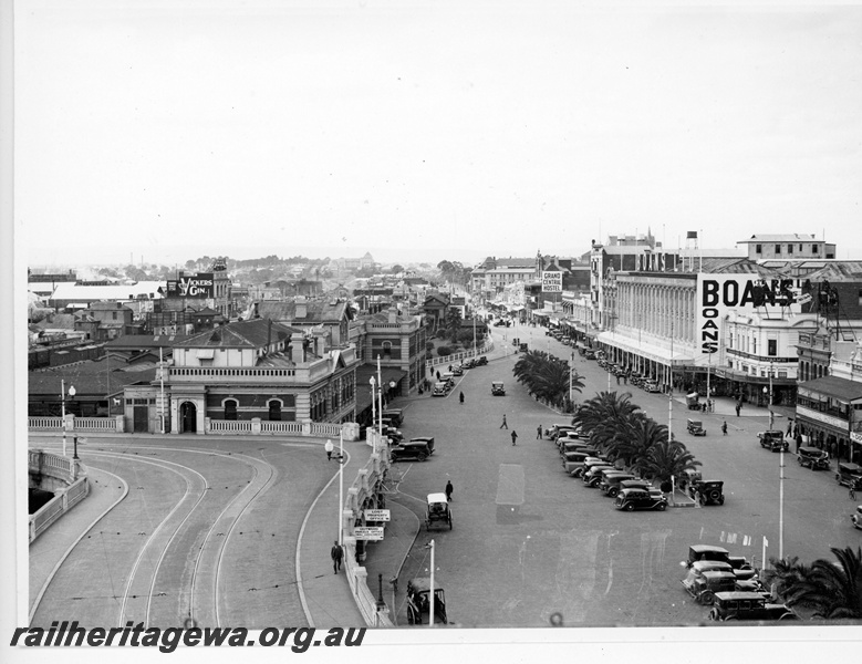 P20084
Perth city railway station building, horseshoe bridge, Wellington Street, cars, palm trees, shops, pedestrians, 