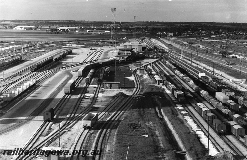 P20731
West Merredin Marshalling Yard - aerial view looking east. Narrow gauge yard on the right, yard masters office  in centre of photo. Standard gauge yard on the left. RAAF World War II hangers in the background. EGR line. 
