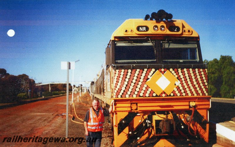 P20754
NR class 52 ( indigenous livery) & unidentified NR class head special Indian Pacific to commemorate 100 years of Commonwealth Railways into Kalgoorlie.  Malcolm Searle standing alongside locomotive. EGR line. 
