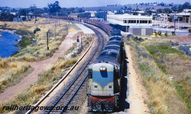 P20771
K class 201 leads 3 other unidentified K classes (all locomotives light blue livery) hauling loaded iron ore train from Koolyanobbing to Kwinana through Northam. New Northam station in photo and Mortlock River to left of train. EGR line.
