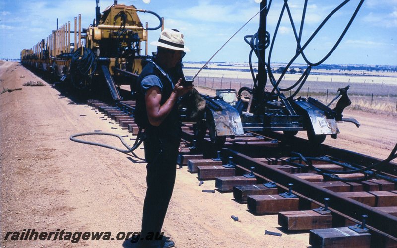 P20773
Standard gauge railway construction near Doodlakine. Guard Stan Williams directs operations by portable radio. EGR line. 
