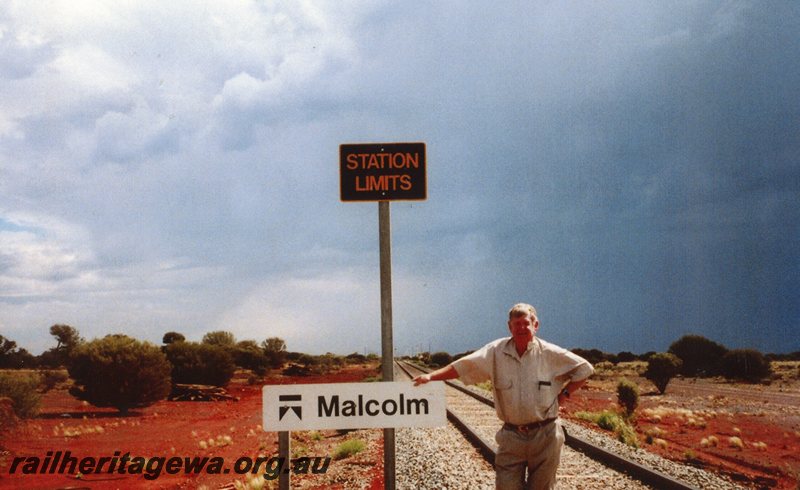 P20780
Malcolm-  station limits sign and nameboard with Malcolm Searle. KL line. 
