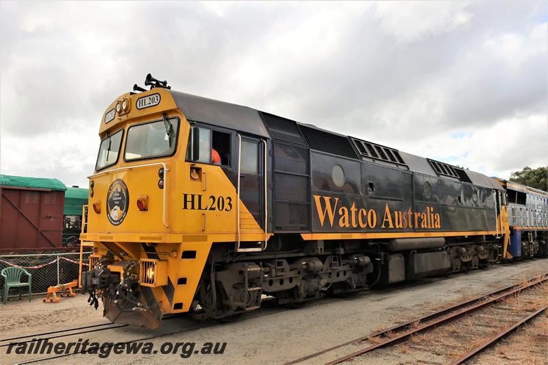P21010
Watco Australia loco HL class 203, yellow and black livery passing through the site of the Rail Transport Museum, Bassendean heading towards UGL's plant, front and side view.
