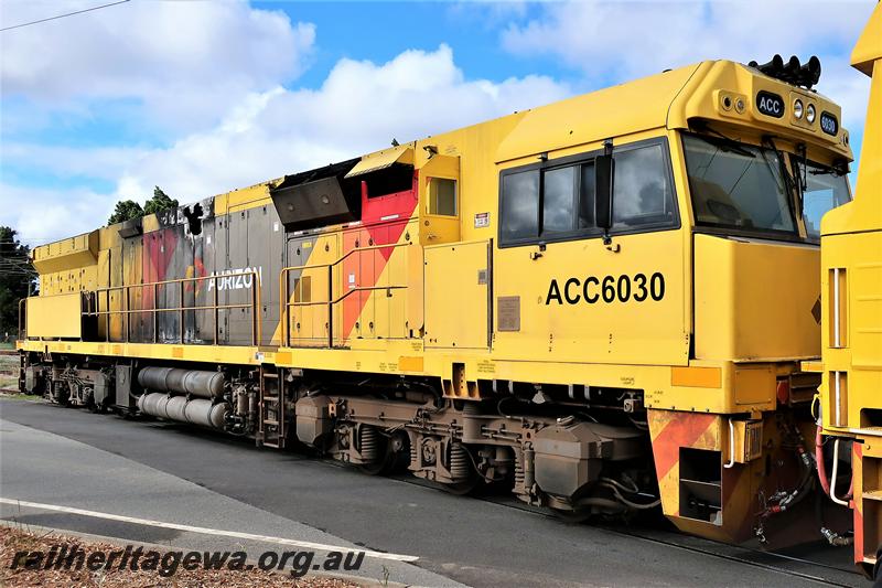 P21016
Aurizon ACC class 6030 in the yellow, red and grey livery crossing Railway Parade, Bassendean en rout to YGL's plant for repairs, The damage is clearly seen in this side and front view. 
