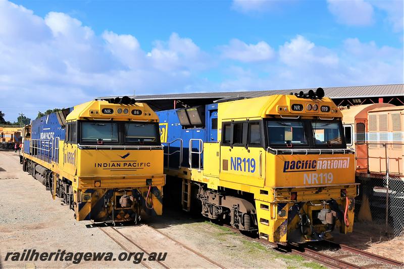 P21020
Pacific National locos NR class86 and NR class 119 side by side on the tracks passing through the Rail Transport museum, side and front view
