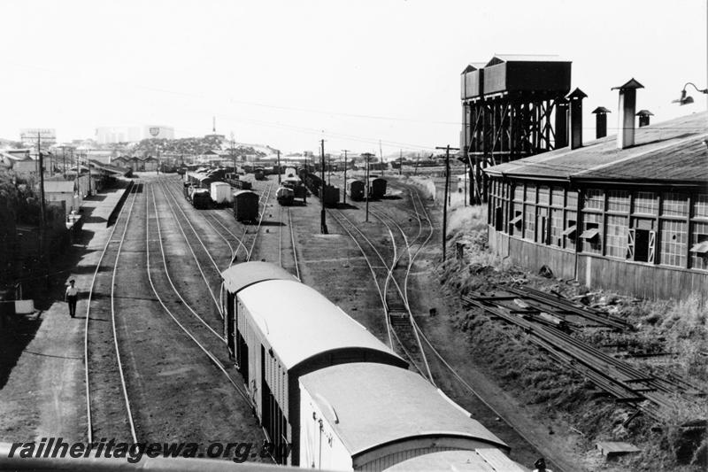 P21121
Station, station buildings, canopy, platform, yard, rakes of wagons, water tanks, roundhouse, BP storage tank on skyline, Bunbury, SWR line, view from elevated position
