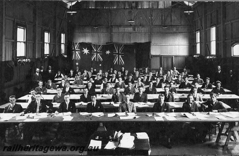 P21150
Large group of railway employees in a hall sitting their Safe Working examinations at the Railway Institute, Perth, view looking down the hall
