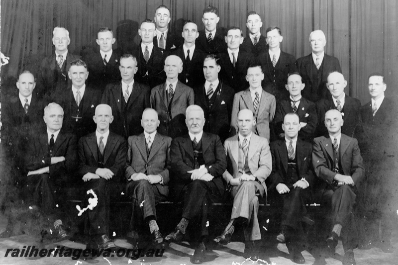 P21180
Group photo of Western Australian Railway & Institute Council 1937. Back row - W. Kemp, R. G. Cox, C. A. Pearce .3rd row - S. Gorman, C. A. Robinson, S. R. Thomas, E. Clay, A. A. Townsend, E. W. Morris, F. S. Barnett. 2nd row - W. Mills, H. Hamilton, W. E. Ellery, G. W. Hall, W. Milligan, H. E. Webb, J. B. Hilton, F. T. Farrell, C. R. Stubbs. Front row - F. C. Carlin, S. L. Roberts, S. F. L. Hussey, J. W. R. Broadfoot, F. J. Merifield, R. M. T. Smith, W. Raynes. Absentees - J. C. Clunas, A. S. Hall, L. T. Hickey, A. Marshall, E. G. Ridley.
