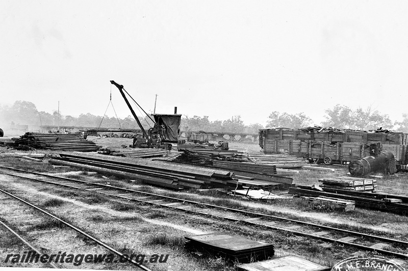P21253
Early view of salvage area, timber, wagons, track, crane, boiler, workers, wooden trestle bridge in background, Midland, ER line, ground level view, c1910
