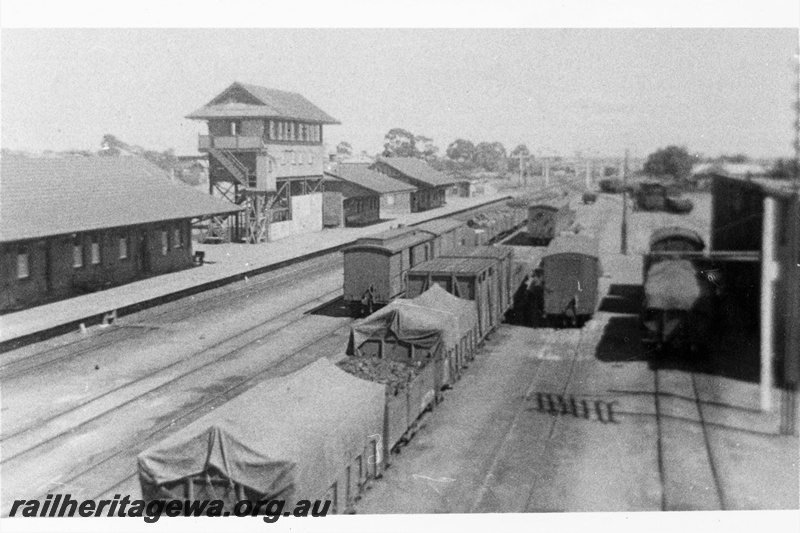 P21304
KW class wagons, vans, station building before extension, signal box, other platform buildings, sidings, goods shed, yard, Merredin, EGR line, view from elevated position, c1931-1938
