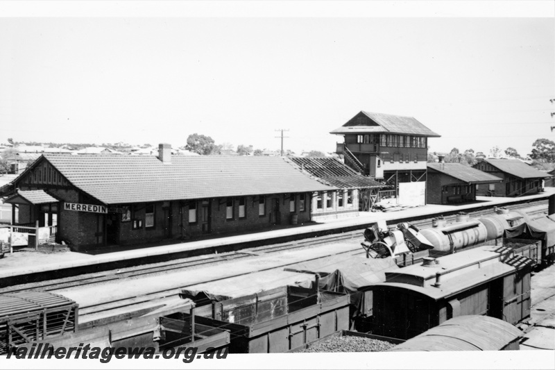P21306
JQ class tank wagon in Commonwealth Oil Refineries livery, JM class tank wagon, assorted wagons and vans, station building with extension under construction, signal box, other platform buildings, Merredin, EGR line, view from elevated position, c1938-1955
