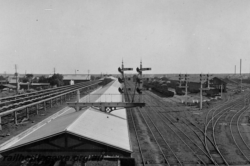 P21342
Kalgoorlie station and yard from signal box looking west. The construction of the Trans platform on left side of photograph, bracket signal projecting through the roof of the platform canopy,  EGR line.
