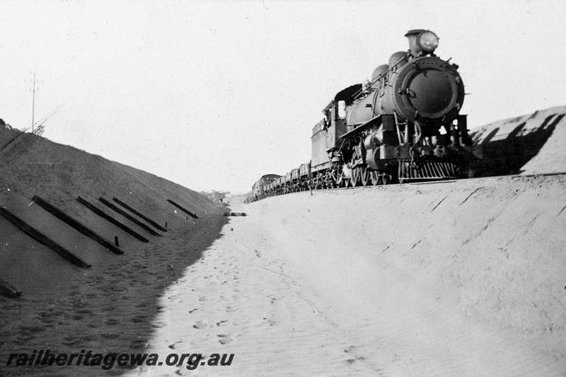 P21358
L class steam loco on goods train, Indarra deviation, NR line, side and front view, c1936
