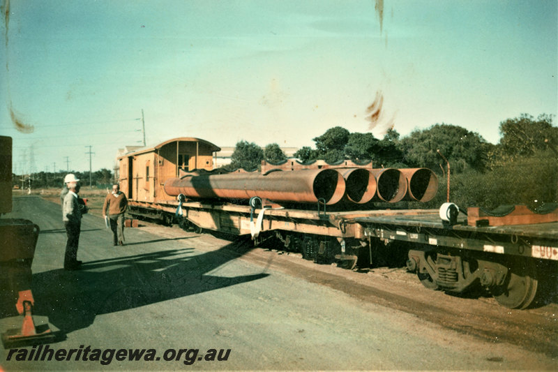 P22857
Steel pipes loaded on to flat wagon, with new webbing straps ready to secure load, van, workers, Kwinana, side and end view
