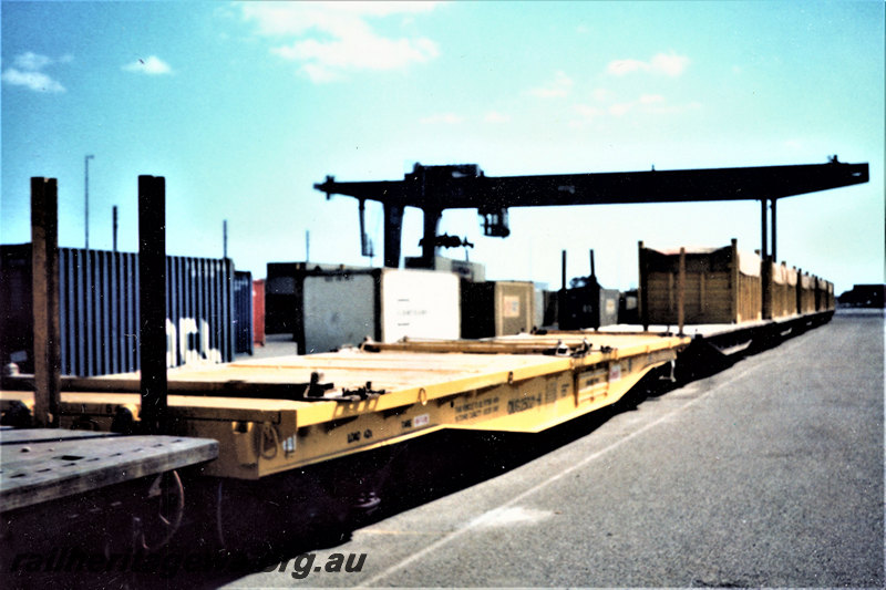 P22860
QUG class wagon, other wagons, gantry crane, containers, end and side view from trackside
